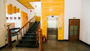 A staircase with wooden railings and a fire extinguisher near the base. - Dong Phuong Hotel (Quy Nhon Nam)