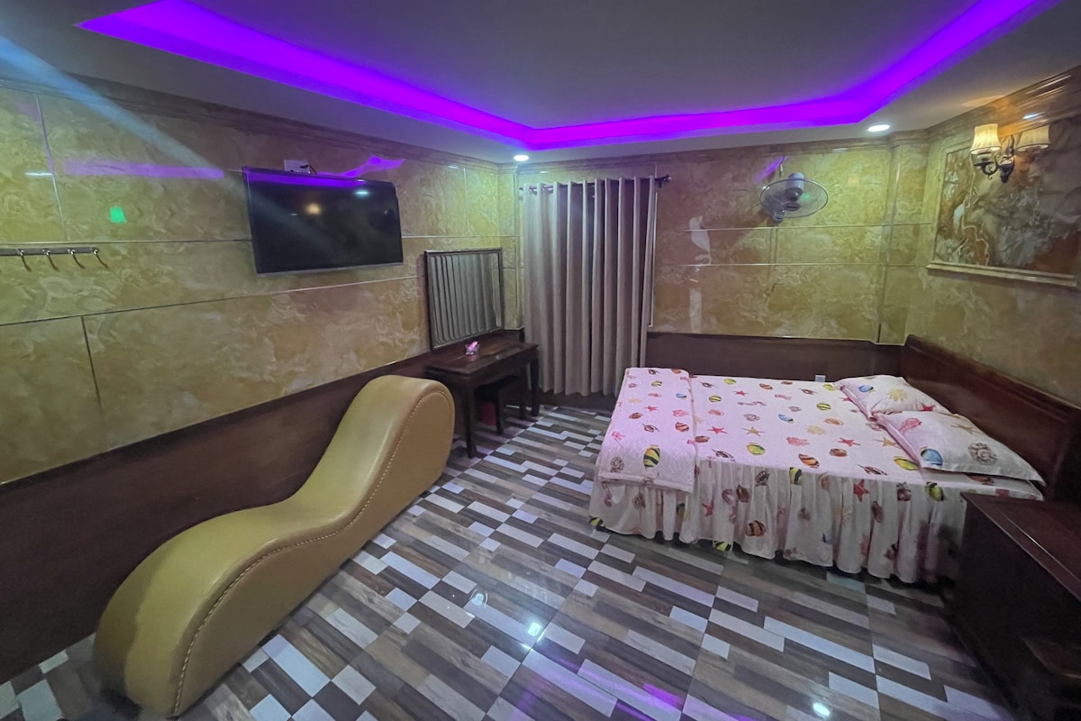 Una habitación de hotel con una cama, un sofá, un televisor y un piso con diseño.