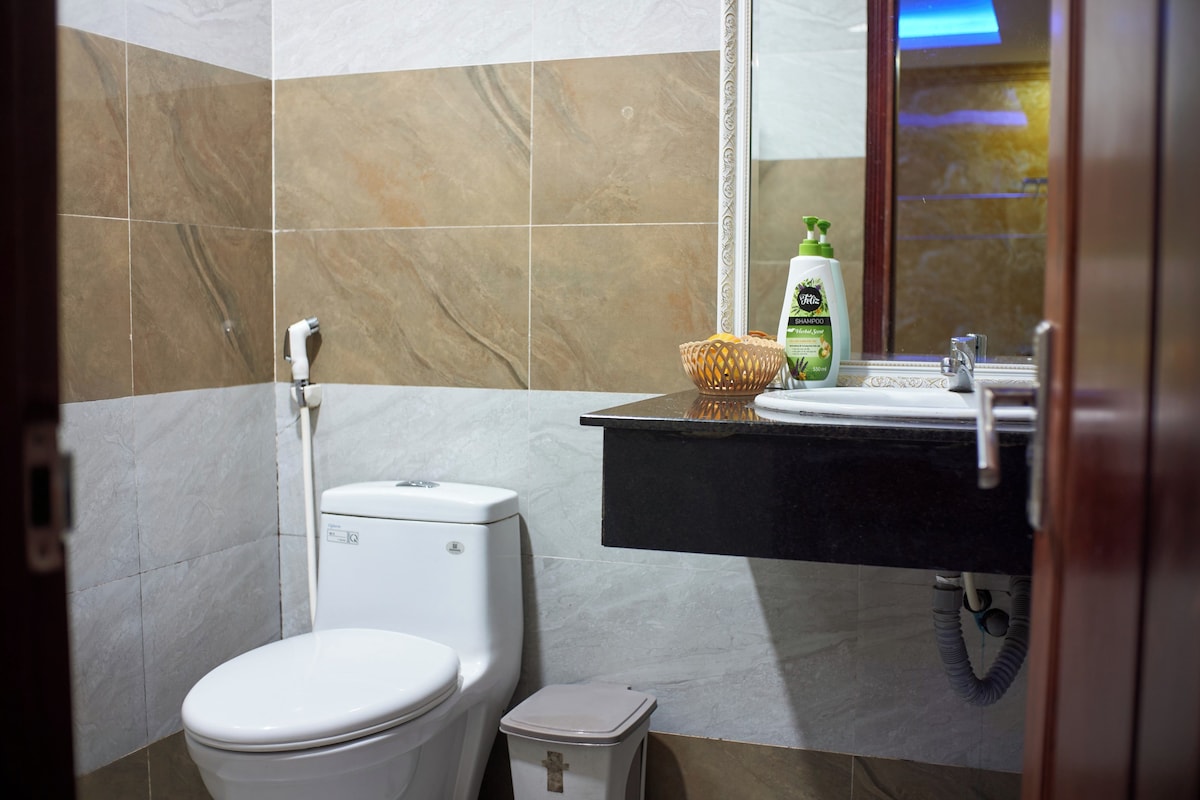 Un baño con inodoro, lavamanos y espejo.