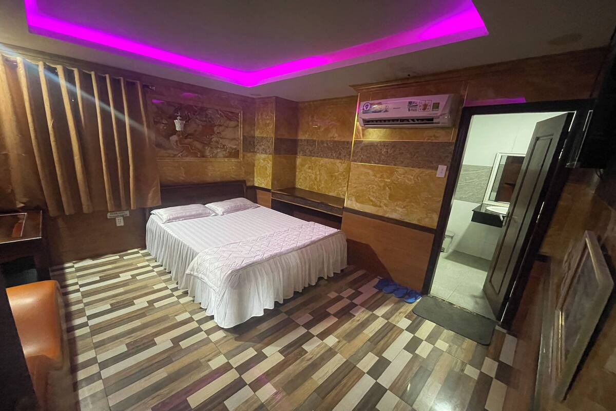 A hotel room with a bed, a desk, and a wardrobe.