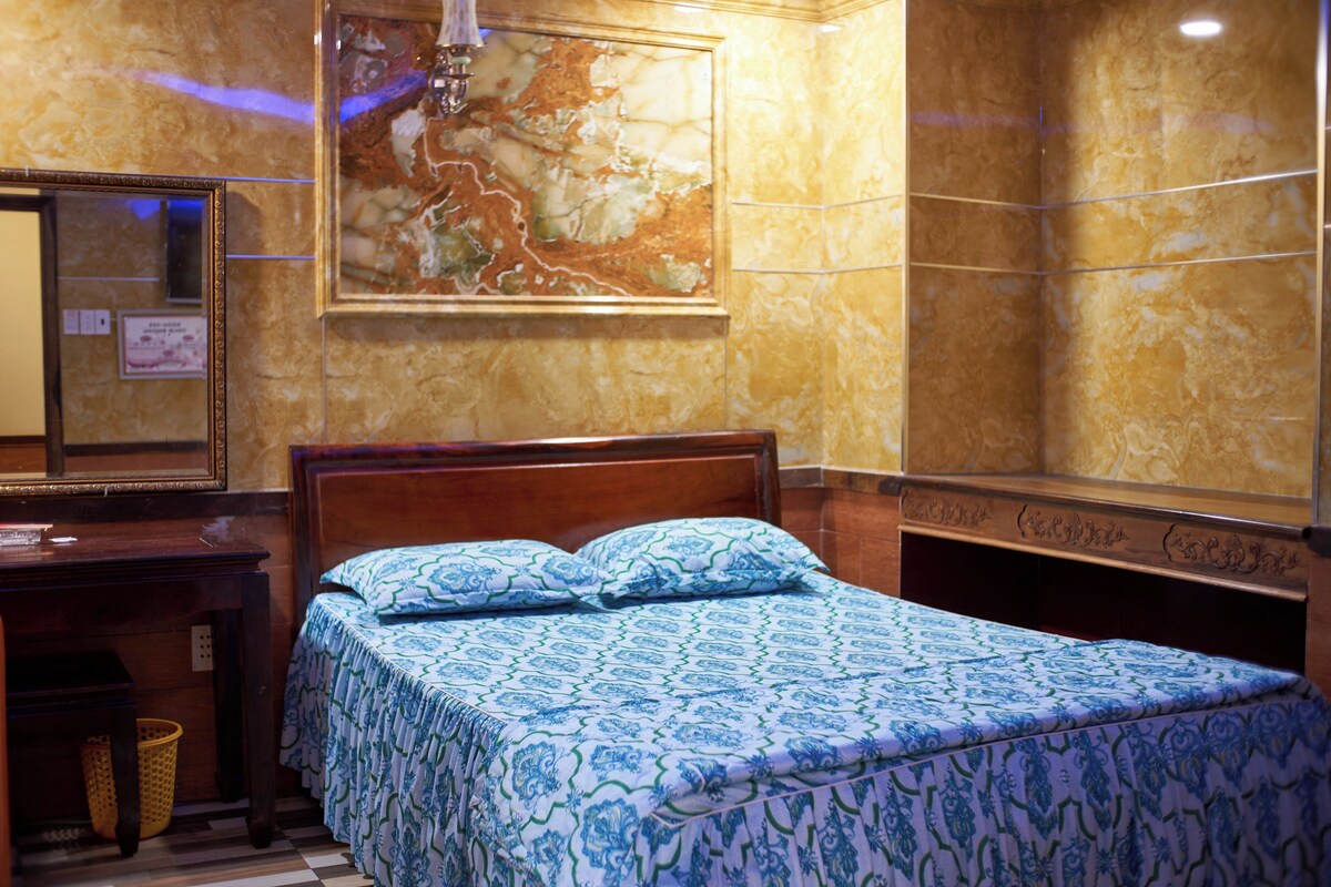 Ein Hotelzimmer mit einem hölzernen Bett, einem großen Spiegel und einer Karte an der Wand.