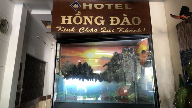A hotel sign with the name "HONG DAO" and a tagline "Kinh Chao Zui Khach!"