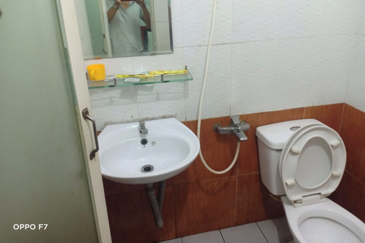 Een badkamer met een wit wastafelmeubel, een toilet en een spiegel.