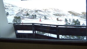Schneebedeckte Berglandschaft mit Holzbalkon und Metalldach.