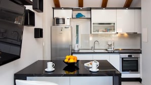 A modern kitchen with a central island, built-in appliances, and a minimalist design. - Apartment Mali Skoj (Dubrovnik)