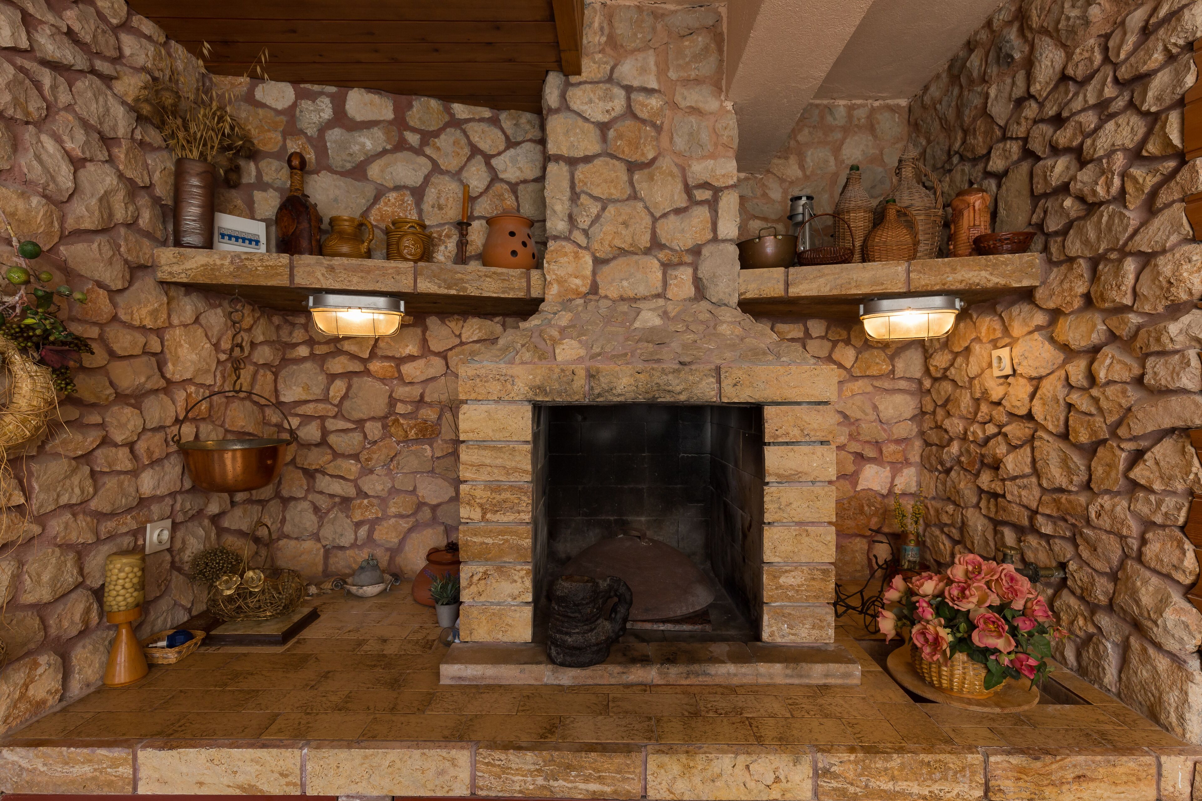 A stone fireplace with shelves above and decorative items around it.