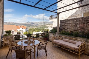 A covered outdoor patio with wicker furniture, a table, and a sofa. - Big Terrace Apartment (Dubrovnik)