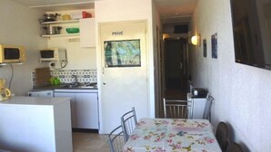 A compact kitchen with a dining area, a microwave, a stove, and a refrigerator. There is a door labeled "PRIVÉ" and a small window. - Family studio for 6, ski-in/out, balcony, free parking, ski locker (Arette)