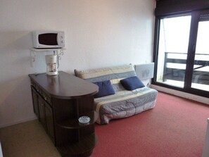 A small room with a bed, a coffee maker, a microwave, and a window. - Studio for 6 at the slopes with balcony, ski locker, and free parking (Arette)
