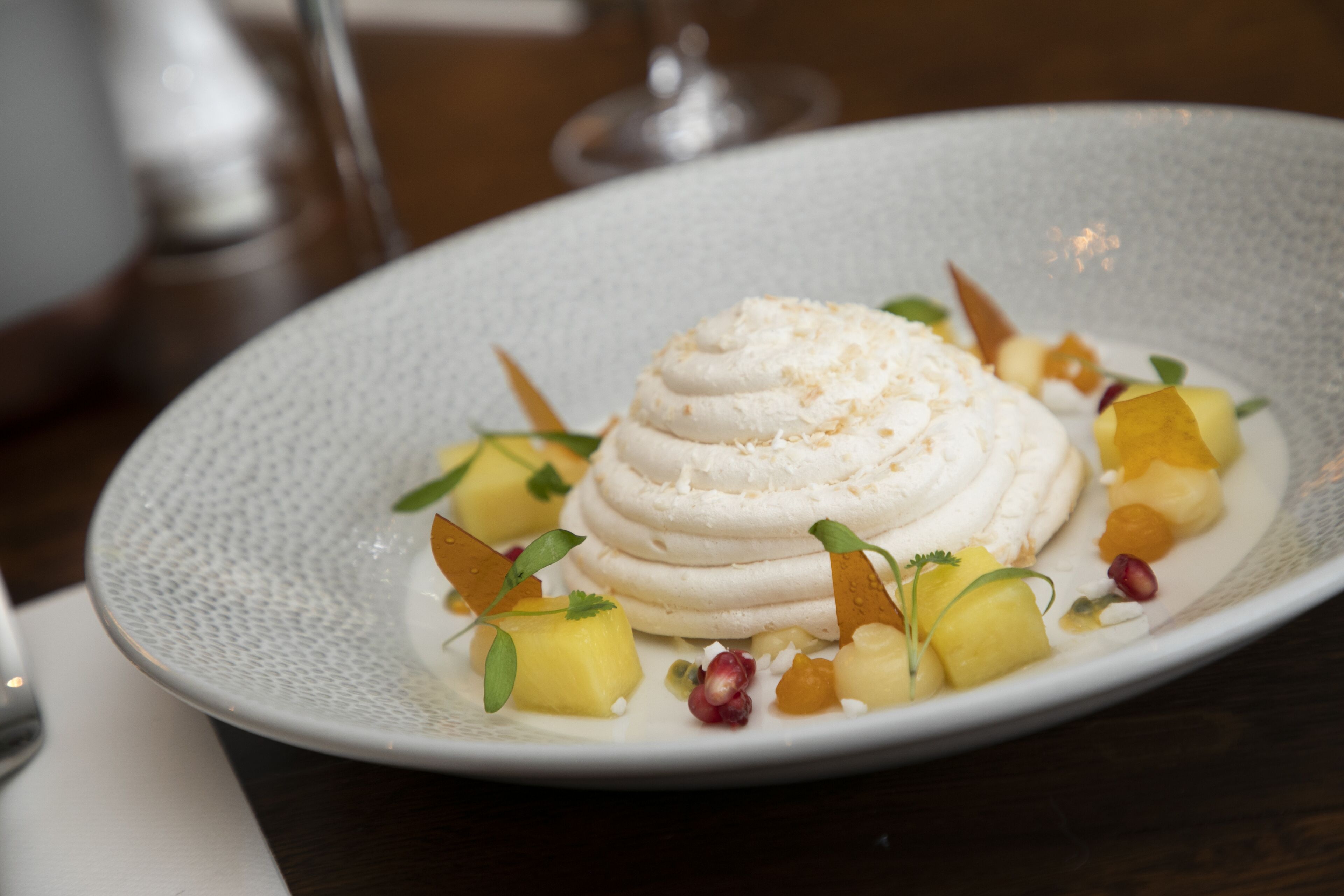 Un dessert su un piatto con frutta e decorazioni.