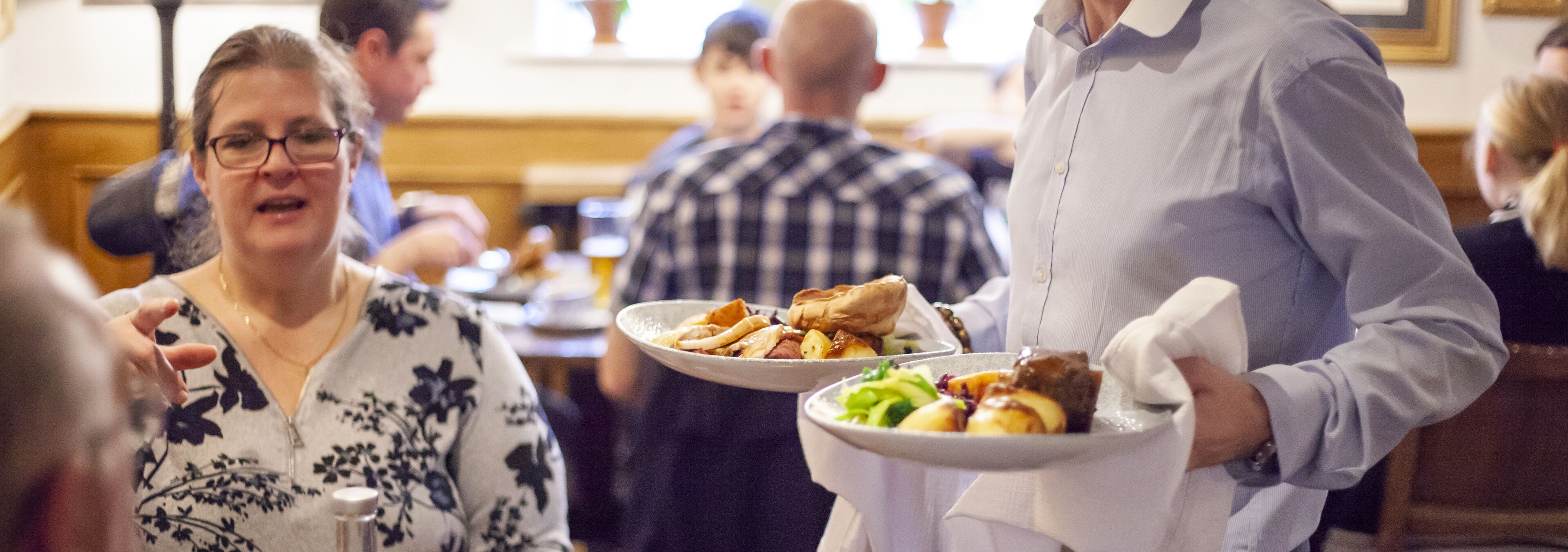 A restaurant setting with diners and waitstaff.