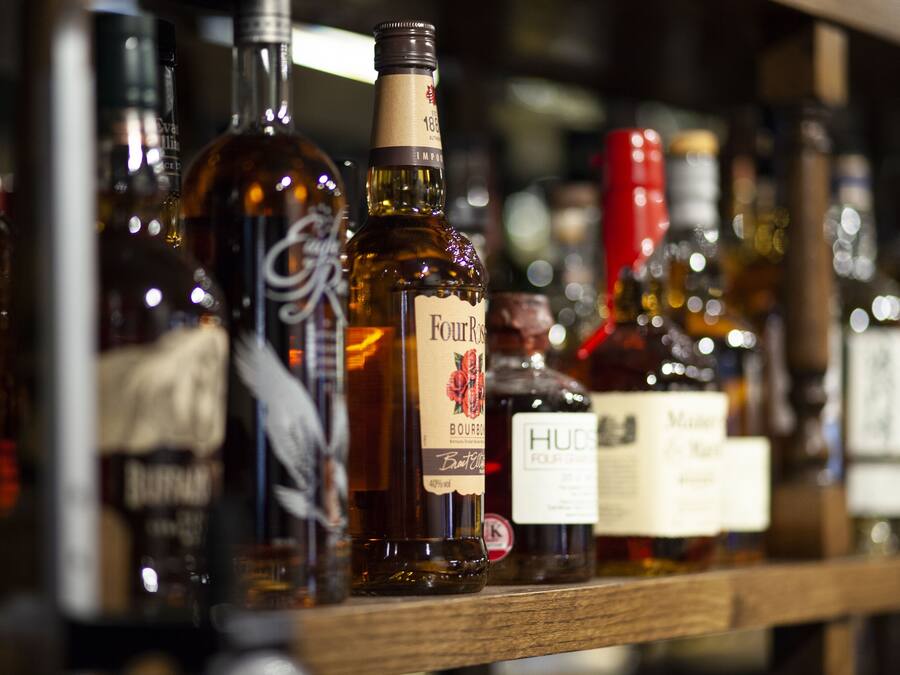 A shelf with various bottles of liquor.