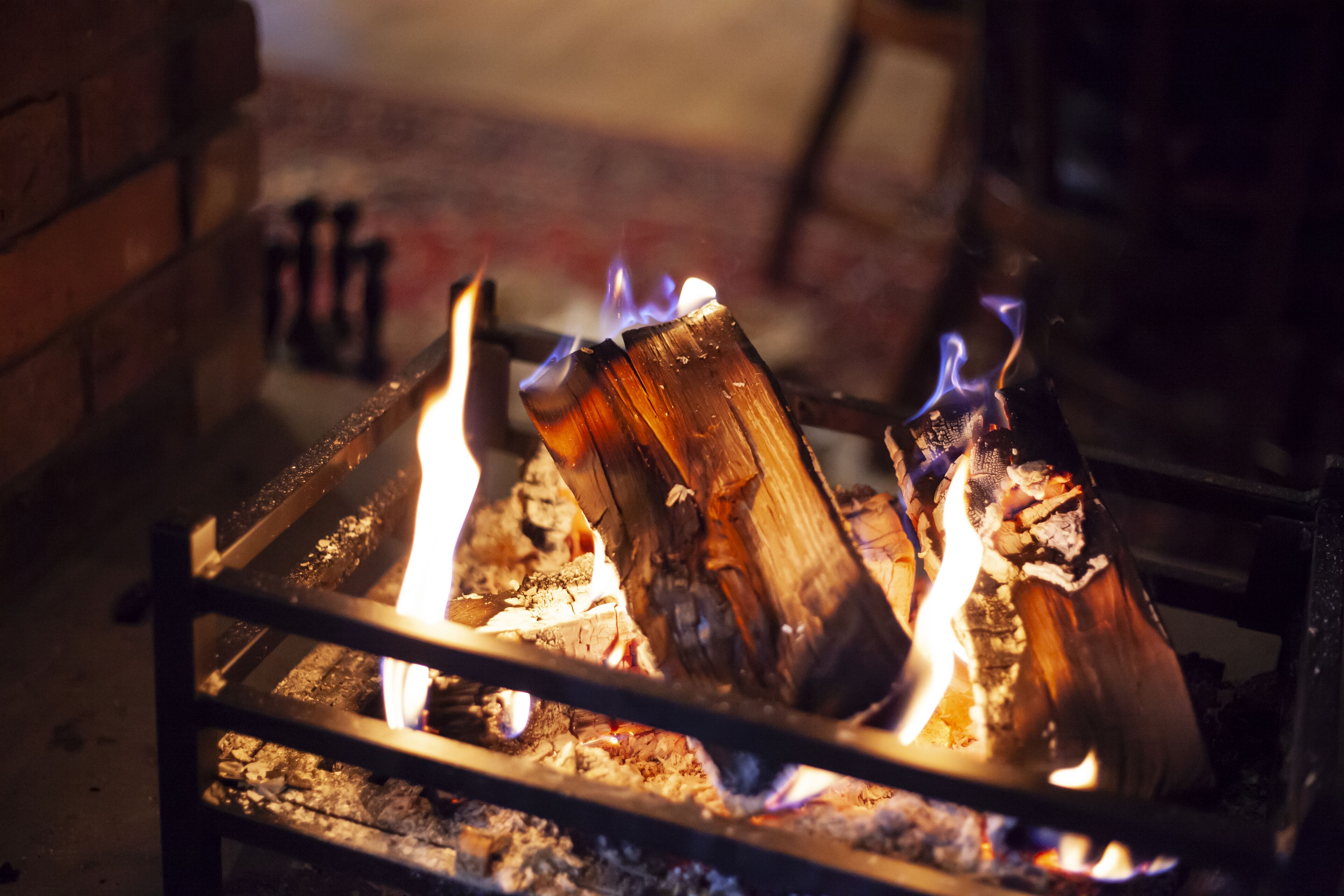 A close-up of a fireplace with burning logs and flames.