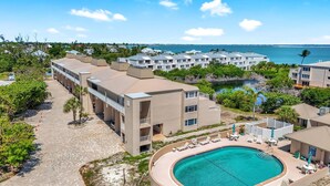 A resort with a swimming pool, multiple buildings, and a view of the ocean. - LIGHTHOUSE A311 - Gorgeous views from top floor Sanibel condo (Sanibel)