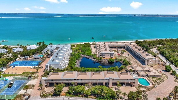 An aerial view of a resort with a swimming pool, tennis courts, and a beach. - LIGHTHOUSE A311 - Gorgeous views from top floor Sanibel condo (Sanibel)