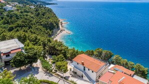 A coastal town with a beach, houses, and a clear view of the sea. - Rooms Sani (Brela)