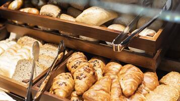 Una vitrina de panadería con diferentes tipos de pan y pasteles.
