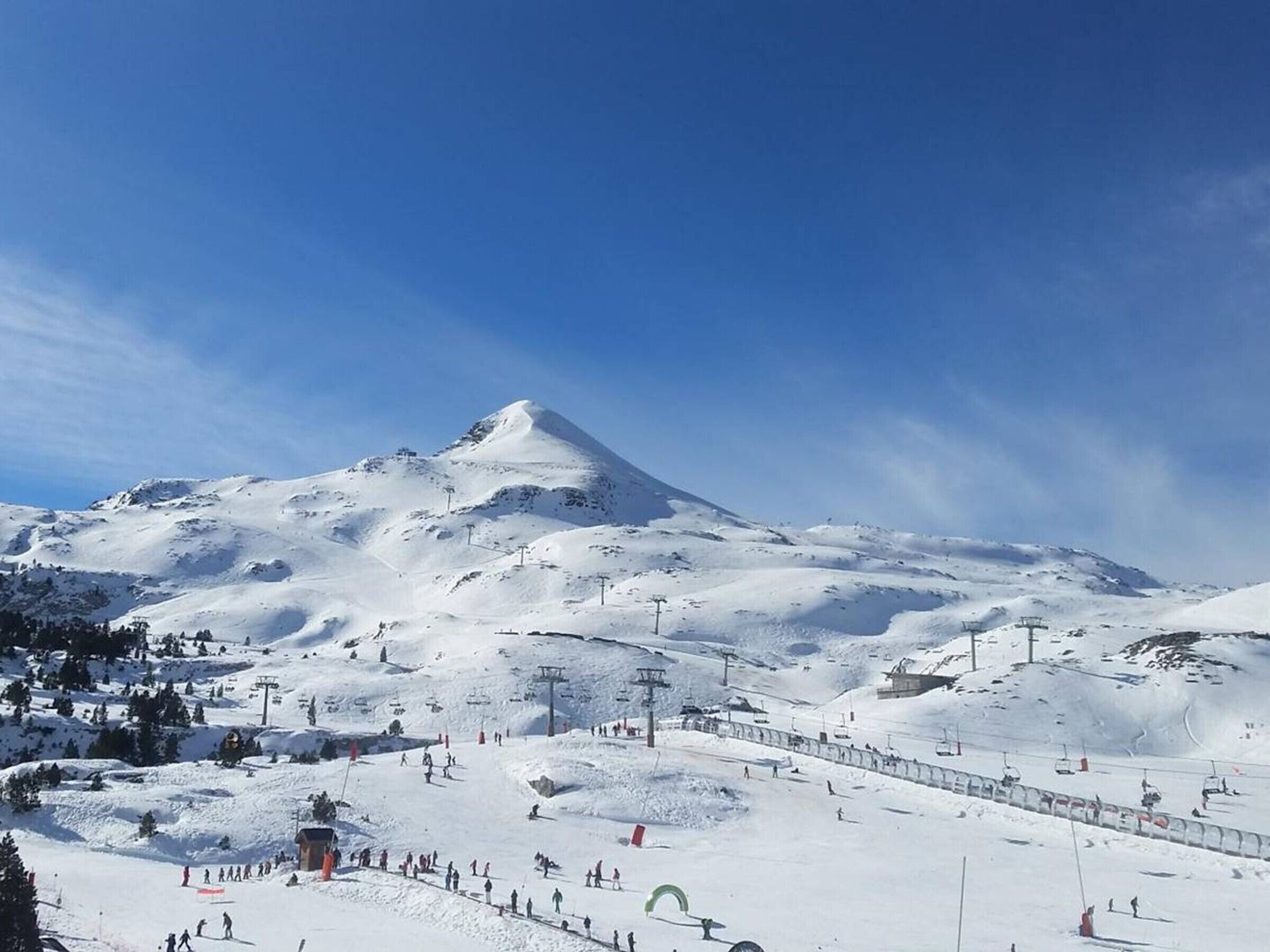A snow-covered mountain with a ski slope and a ski lift.