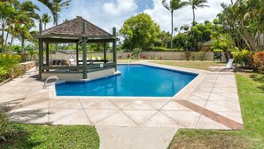 A swimming pool with a gazebo, surrounded by palm trees and a well-maintained lawn. - Honu Kai@Turtle Bay- Pool, AC, Golf, Beach (Kahuku)