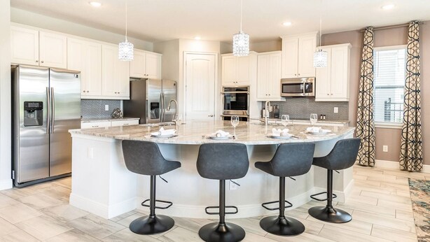 A modern kitchen with a central island, stainless steel appliances, and bar stools.
