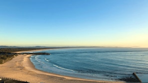 Enjoy a serene beach experience with a natural barrier of rocks separating the shore from the ocean.