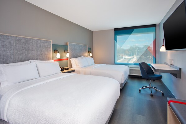 A hotel room with two beds, a desk, a chair, and a large window offering a view. - avid hotel Detroit Warren by IHG (Warren)