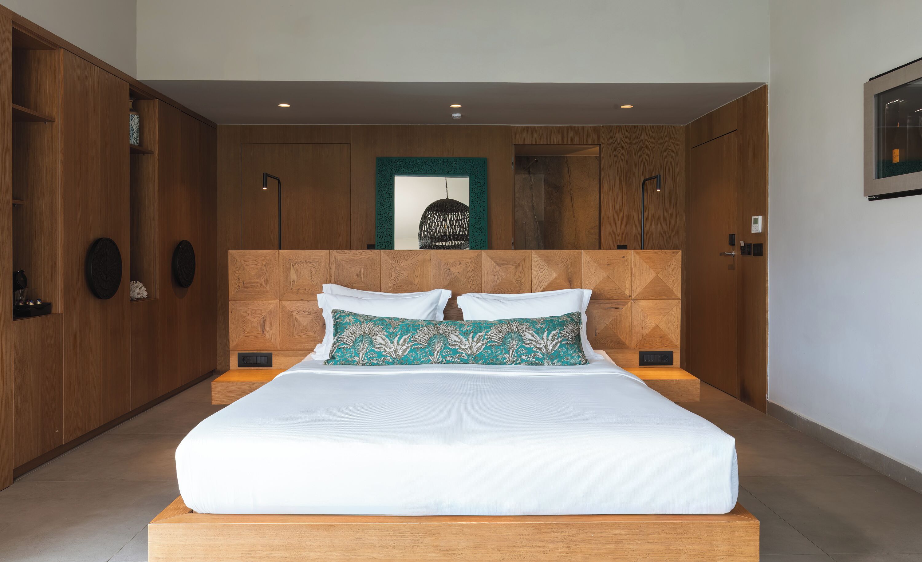 A modern bedroom with a large bed, wooden headboard, and built-in wardrobe.