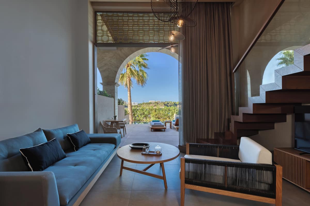 A modern living room with a sofa, a round coffee table, and a TV stand.