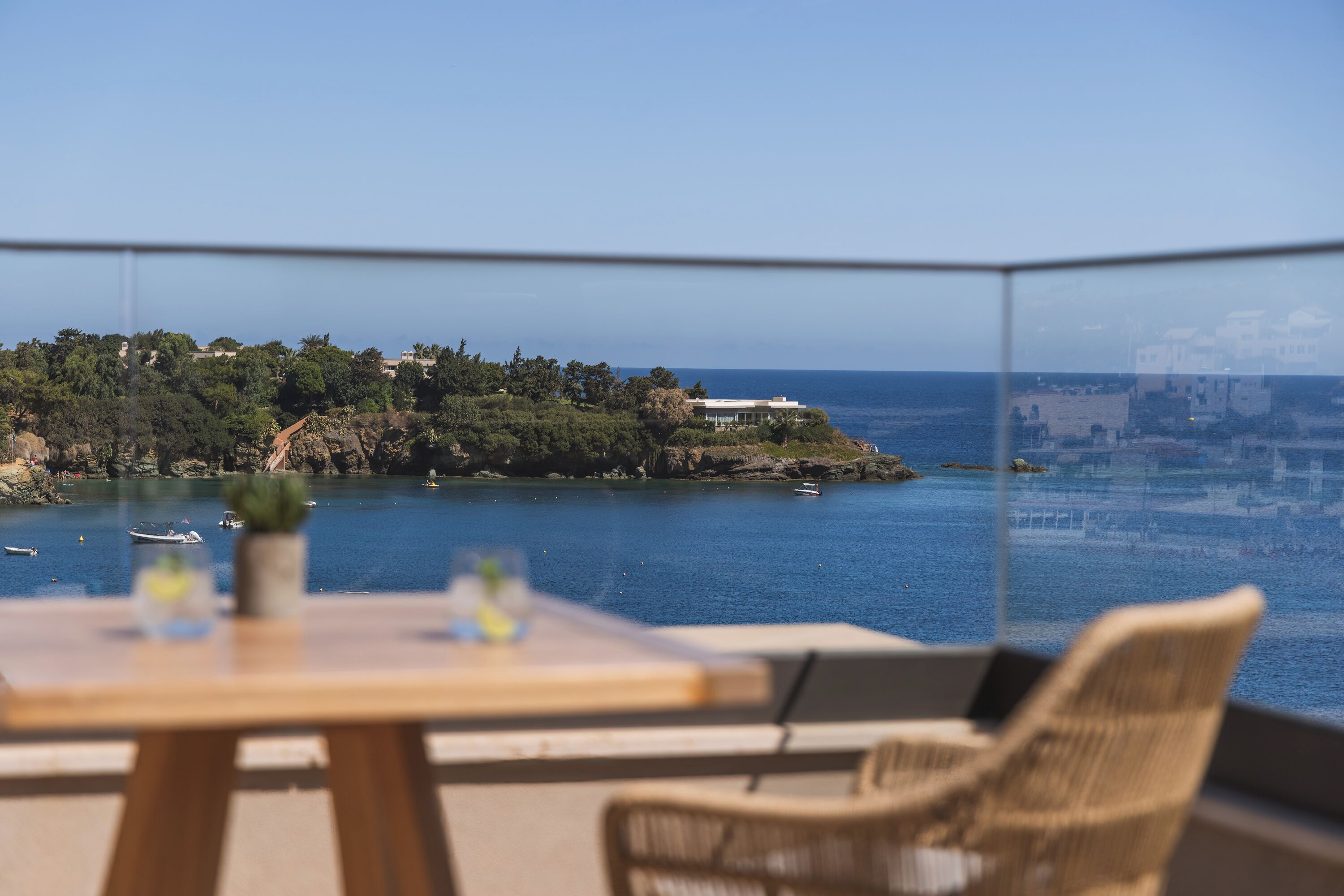 Een balkon met uitzicht op zee, een tafel en een stoel.