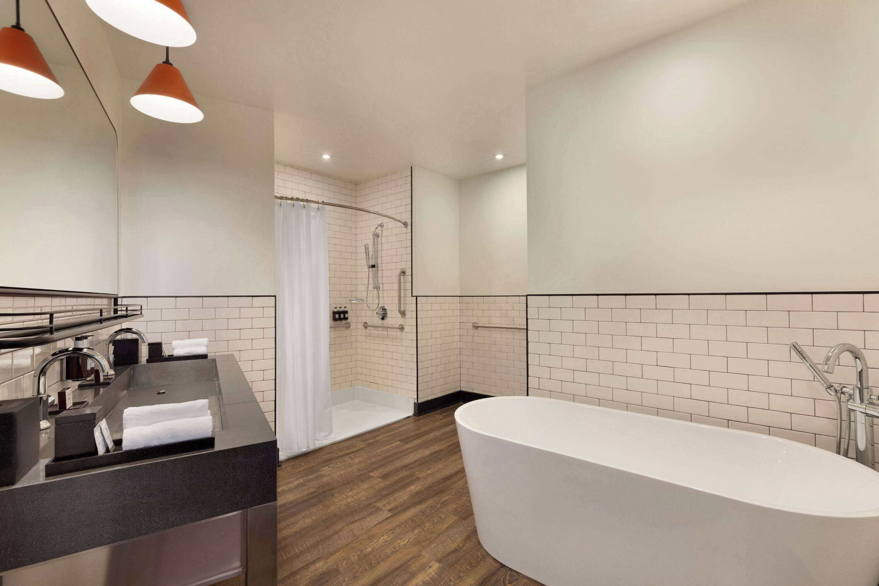 Une salle de bain moderne avec une baignoire sur pieds, un meuble-lavabo avec un miroir et un espace douche.