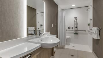 Een moderne badkamer met een groot wastafel, spiegel en douche.