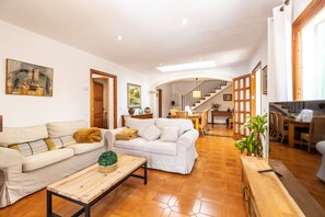 A spacious living area with a sofa, coffee table, and a staircase leading to an upper level. - Pollensa holiday villa 31 with pool, well situated, Creus (Pollensa / Pollença)