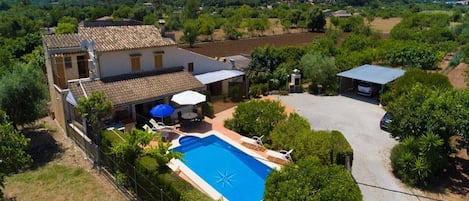 Una villa con piscina, area relax esterna e vista sul paesaggio circostante.