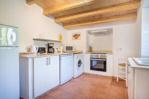 A compact kitchen with white cabinets, a washing machine, a microwave, and a built-in oven. - Walking distance to town, two bedroom villa Jero. (Pollensa / Pollença)