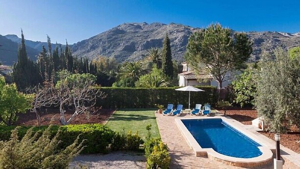 Une piscine avec des chaises longues et une vue sur les montagnes.