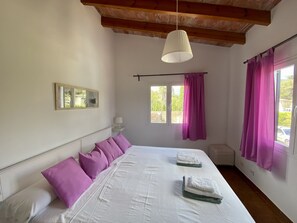 A bedroom with a bed, pillows, a hanging lamp, a window with curtains, and a wall-mounted picture. - Walking distance to town, two bedroom villa Jero. (Pollensa / Pollença)