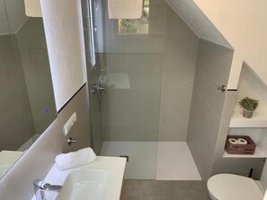 A modern bathroom with a glass shower enclosure, a white sink, and a toilet. - Walking distance to town, two bedroom villa Jero. (Pollensa / Pollença)