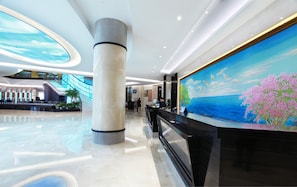 A modern lobby with a reception desk, a large mural, a staircase, and a glass ceiling. - Xiamen Jingmin Central Hotel (Xiamen)