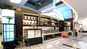 A modern hotel lobby with a marble floor, a central display case, and a curved ceiling design. - Xiamen Jingmin Central Hotel (Xiamen)