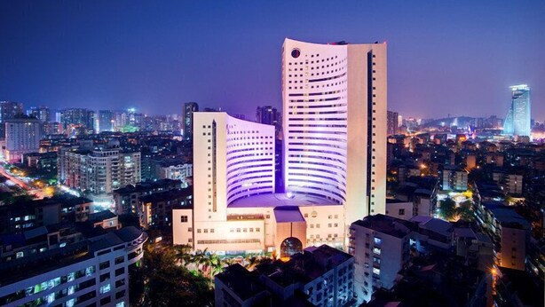 A high-rise building with a curved facade and a prominent entrance. - Xiamen Jingmin Central Hotel (Xiamen)