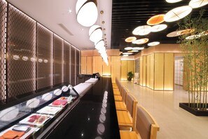 A modern interior with a long counter, seating area, and decorative lighting. - Xiamen Jingmin Central Hotel (Xiamen)