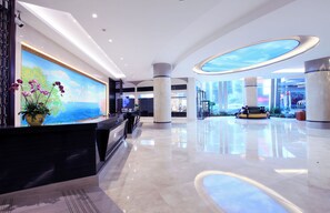 A spacious lobby with a reception desk, large columns, and a modern ceiling design. - Xiamen Jingmin Central Hotel (Xiamen)