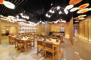 A modern restaurant with wooden furniture and unique ceiling lights. - Xiamen Jingmin Central Hotel (Xiamen)
