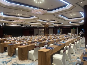 A conference room with rows of tables, chairs, and nameplates, equipped with microphones and laptops. - Xiamen Jingmin Central Hotel (Xiamen)