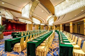 A conference room with long tables, chairs, and a stage. - Xiamen Jingmin Central Hotel (Xiamen)