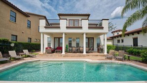 Une maison à deux étages avec une piscine, du mobilier d’extérieur et un espace patio.