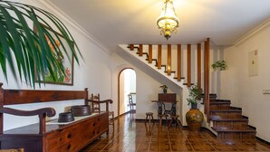 A spacious room with a wooden bench, a dining table with chairs, a staircase, and a large plant. - Pollensa walking distance traditional villa Miquel (Pollensa / Pollença)