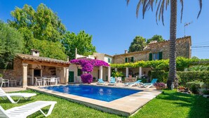 A pool with lounge chairs, a stone building, and lush greenery. - Pollensa walking distance traditional villa Miquel (Pollensa / Pollença)