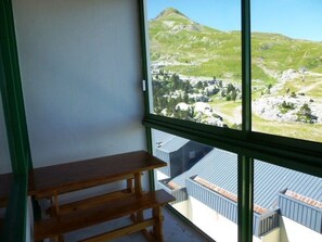Una habitación con un banco de madera y un ventanal que ofrece vistas a un paisaje montañoso.