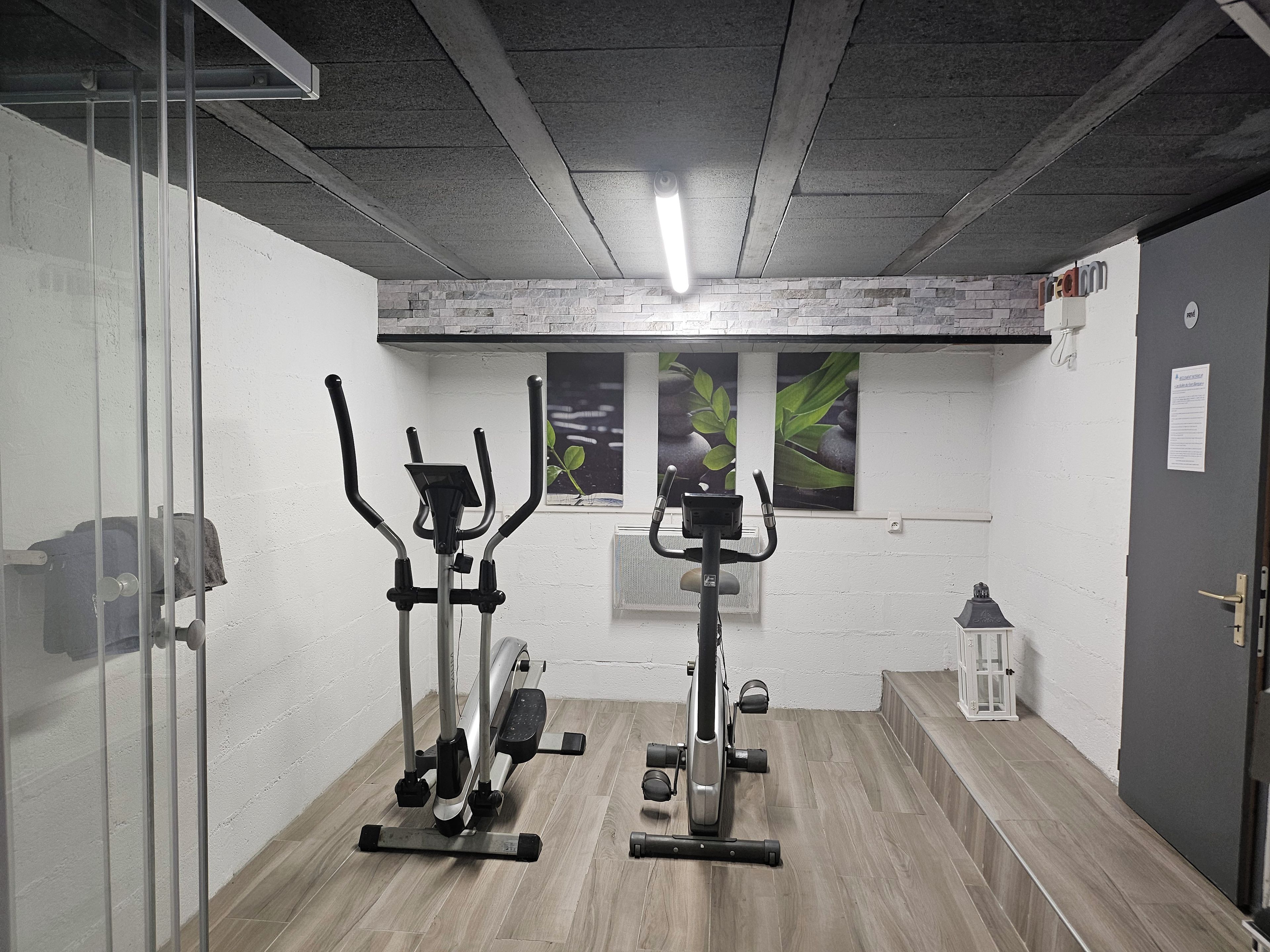A gym with exercise equipment, a window with a plant, and a door with a sign.